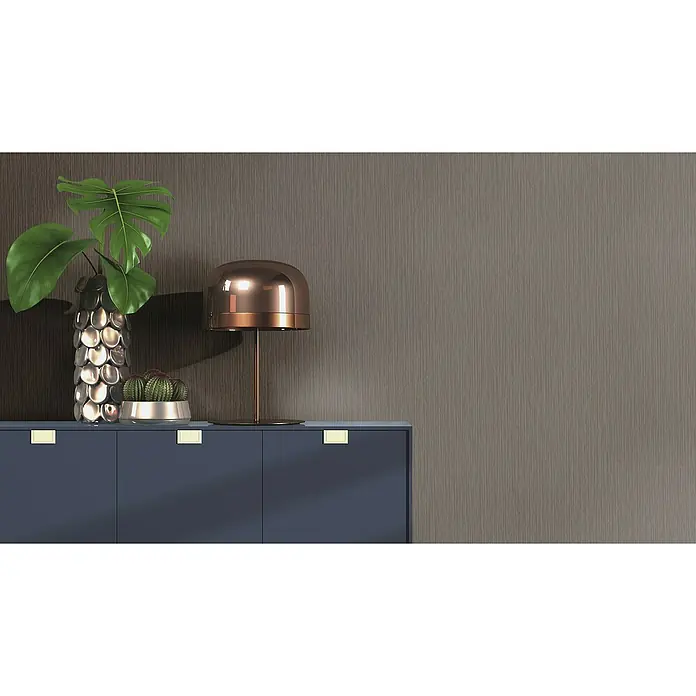 Rasch Curiosity Vliestapete Längs-Uni - Braunschwarz, Uni, 10,05 x 0,53 m - Elegantes Sideboard in Marineblau mit goldenen Griffen, verziert mit einer silbernen Vase, einer Lampe und einem Kaktus.