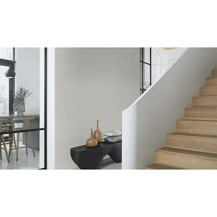 Rasch Welcome home Vliestapete Struktur-Uni - Nebel, Uni, 10,05 x 0,53 m - Das Bild zeigt eine moderne Inneneinrichtung mit einer strukturierten Tapete und einer Holztreppe. Die Dekoration besteht aus Vasen und Kissen auf einer Bank.