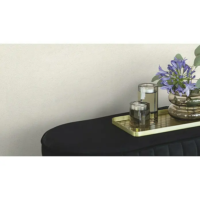 Rasch Factory V Vliestapete Metalloptik - Hellgrau, Uni, 10,05 x 0,53 m - Elegante Nahaufnahme eines schwarzen Konsolentisches mit stilvoller Dekoration, darunter Gläser und Blumen auf einem goldenen Tablett.