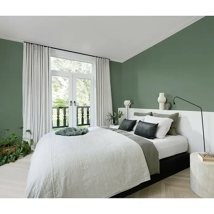 Rasch Wall Textures VI Vliestapete Struktur-Uni - Moosgrün, Uni, 10,05 x 0,53 m - Schlafzimmer mit grünen Wänden, weißen Vorhängen und einer hellen, gesteppten Tagesdecke, die eine ruhige und entspannende Atmosphäre schafft.
