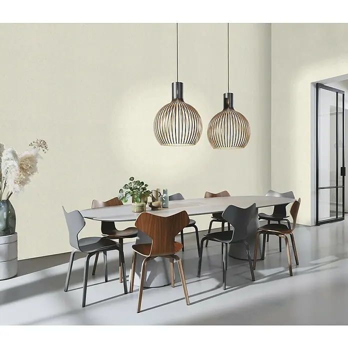 Rasch Welcome home Vliestapete Putzoptik-Uni - Cremeweiß, Uni, 10,05 x 0,53 m - Speisezimmer mit ovalem Tisch, Stühlen und zwei hängenden Holzlampen. Das Interieur wirkt modern und stilvoll.