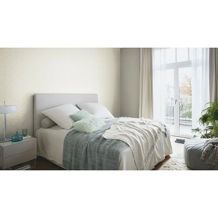 Rasch Welcome home Vliestapete Struktur-Uni - Greige, Grafisch, 10,05 x 0,53 m - Schlafzimmer mit einem großen Doppelbett, Nachttisch mit Lampe und Dekorationsgegenständen, sowie einem weichen Teppich und Vorhängen.