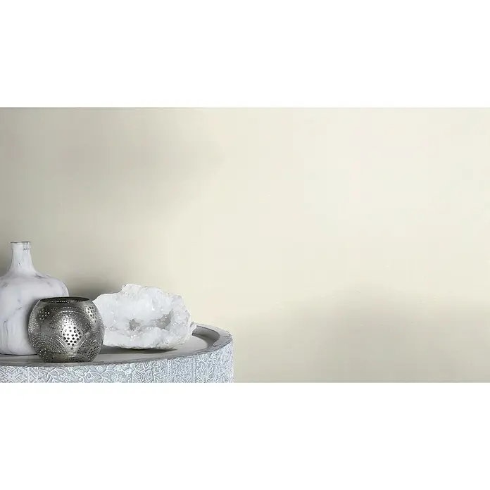 Rasch Wall Textures VI Vliestapete Leinen-Uni - Offwhite, Uni, 10,05 x 0,53 m - Nahaufnahme einer Tischdekoration mit einer marmorierten Vase, einer Metalllaterne und einem Quarzkristall auf einem dekorativen Tisch.