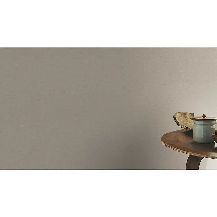 Rasch Country Charme Vliestapete Textil-Uni - Braun, Uni, 10,05 x 0,53 m - Nahaufnahme einer Holzschale und eines hellblauen Keramikgefäßes mit Holzdeckel auf einem runden Holztisch vor einer braunen Wand.