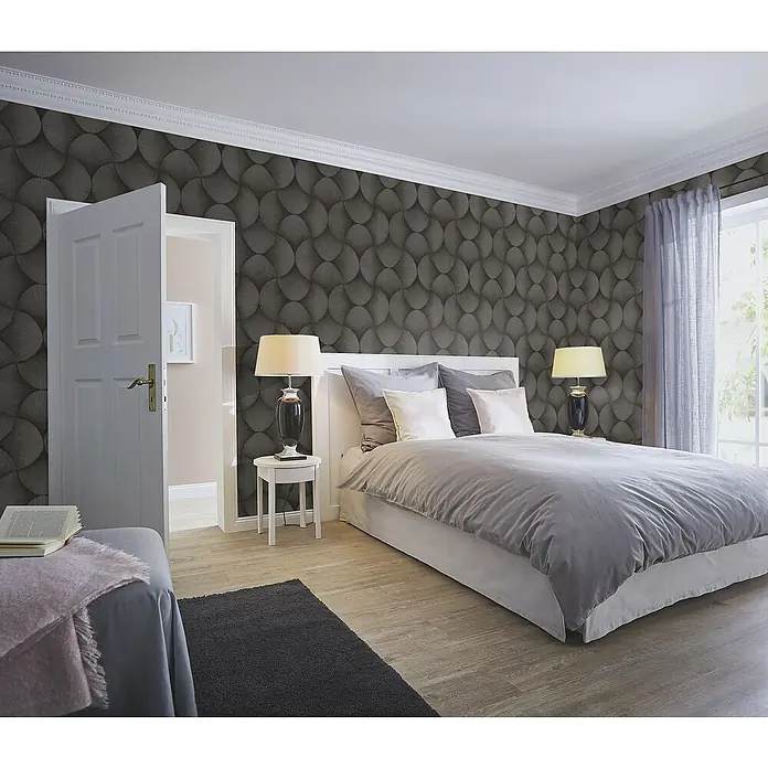 Rasch Sky Lounge Vliestapete Grafik groß - Graubraun, Grafisch, 10,05 x 0,53 m - Elegantes Schlafzimmer mit einer grauen Wandtapete mit Kreismuster, einem weißen Bett und Nachttischen mit Lampen.