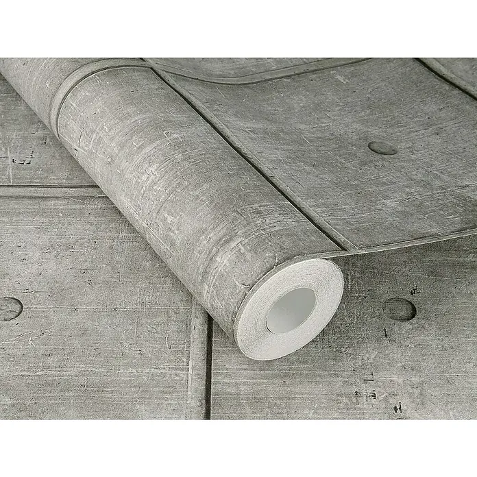 Rasch Factory V Vliestapete Zementfliese - Concrete, Steinoptik, 10,05 x 0,53 m - Ein graues Muster-Tapetenrolle mit Betonoptik, die auf einer Oberfläche mit ähnlichem Design liegt, für ein industrielles Ambiente.