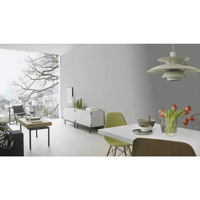 Rasch Color your life Vliestapete Uni-Struktur - Dunkelgrau, Uni, 10,05 x 0,53 m - Die Aufnahme zeigt ein helles Esszimmer mit Designermöbeln und einem stilvollen Beleuchtungskörper über dem Esstisch.