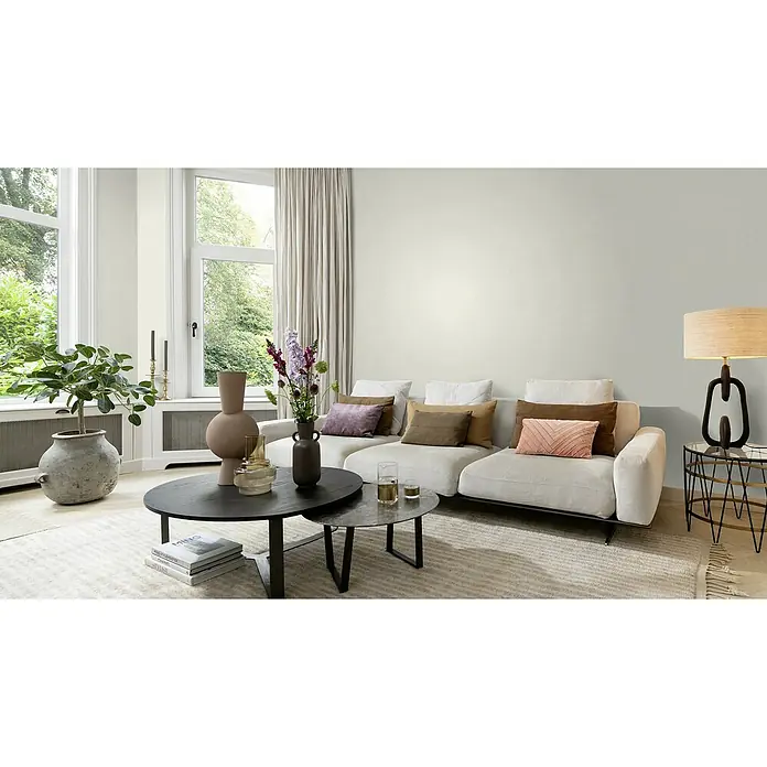 Rasch Welcome home Vliestapete Textil-Uni - Cremeweiß, Uni, 10,05 x 0,53 m - Ein helles Wohnzimmer mit einem großen Sofa, stilvollen Tischen und einer dekorativen Lampe, die eine gemütliche Atmosphäre schaffen.