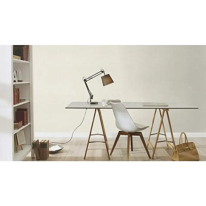 Rasch Color your life Vliestapete Uni-Struktur - Hellbeige, Uni, 10,05 x 0,53 m - Arbeitsbereich mit einem grauen Schreibtisch mit Holzbeinen, einem Stuhl und einer Lampe. Eine Ledertasche steht auf dem Boden.