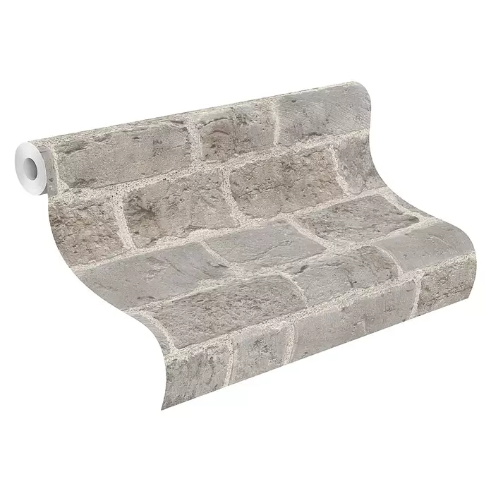 Rasch Symphony Vliestapete Backstein - Steingrau, Steinoptik, 10,05 x 0,53 m - Gerollte Tapete mit grau-beigem Stein- oder Ziegelmuster, schräg von oben gesehen.