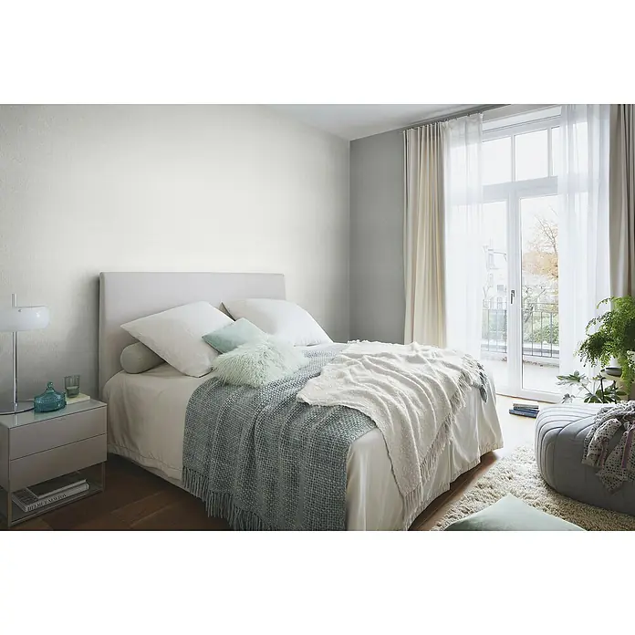 Rasch Sky Lounge Vliestapete Metallic-Uni - Silbergrau, Uni, 10,05 x 0,53 m - Schlafzimmer mit hellem Bett, grauem Nachttisch und Fenstern mit Vorhängen. Der Fokus liegt auf dem stilvollen Bett und der Einrichtung.