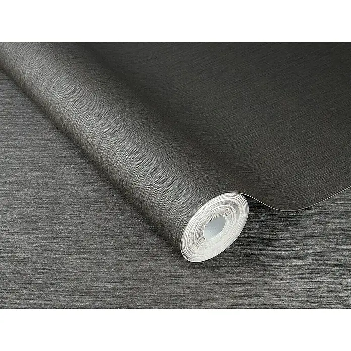 Rasch Sky Lounge Vliestapete Metallic-Uni - Graphit, Uni, 10,05 x 0,53 m - Nahaufnahme einer Rolle dunkler, strukturierter Tapete, die sich ideal für moderne Innenräume eignet. Ihre Oberfläche bietet eine elegante, textile Anmutung.