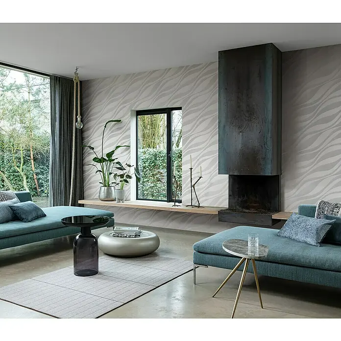 Rasch Sky Lounge Vliestapete Wellen - Platingrau, Wellen, 10,05 x 0,53 m - Ein Wohnzimmer mit einem modernen Kamin und eleganten blauen Sofas. Die gemusterte Tapete verleiht dem Raum eine stilvolle Note.