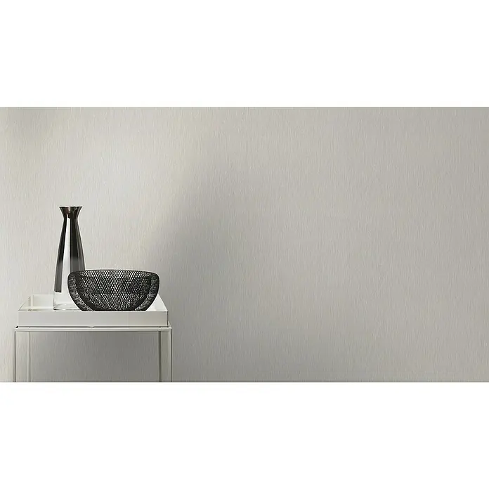 Rasch Color your life Vliestapete Längsuni - Mittelgrau, Uni, 10,05 x 0,53 m - Ein minimalistisches Stillleben mit einer schlanken Vase und einer filigranen Metallschale auf einem modernen Beistelltisch, vor einem schlichten Hintergrund.