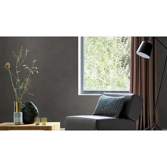 Rasch Factory V Vliestapete Metalloptik - Dunkelbraun, Uni, 10,05 x 0,53 m - Elegantes Interieur mit modernem Sessel, stilvoller Stehlampe und dekorativen Vasen auf einem Holztisch, alles vor einer strukturierten Wand.