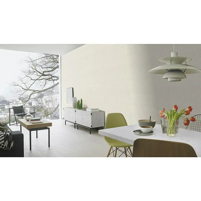 Rasch Welcome home Vliestapete Struktur-Uni - Sand, Uni, 10,05 x 0,53 m - Helles Interieur mit Strukturtapete an der Wand, ergänzt durch eine Pendelleuchte und moderne Möbel. Die Tapete verleiht dem Raum eine elegante Note.