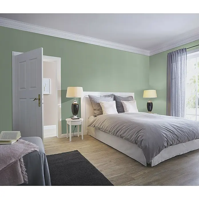 Rasch Country Charme Vliestapete Leinen-Uni - Grüngrau, Uni, 10,05 x 0,53 m - Schlafzimmer mit einem weißen Bett, zwei Nachttischlampen und einem grauen Teppich. Die Wände sind hellgrün gestrichen.