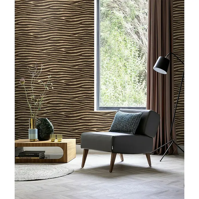 Rasch African Queen III Vliestapete Zebrafell - Dunkelbraun, Tieroptik, 10,05 x 0,53 m - Elegantes Interieur mit einem stilvollen grauen Sessel, der durch sein modernes Design und die bequeme Form besticht.