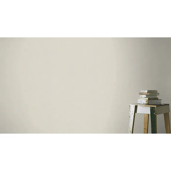 Rasch Wall Textures VI Vliestapete Uni - Hellgreige, Uni, 10,05 x 0,53 m - Bücherstapel auf einem weißen, vintage Hocker vor einer schlichten, beigen Wand. Ein dekoratives Stillleben im minimalistischen Stil.