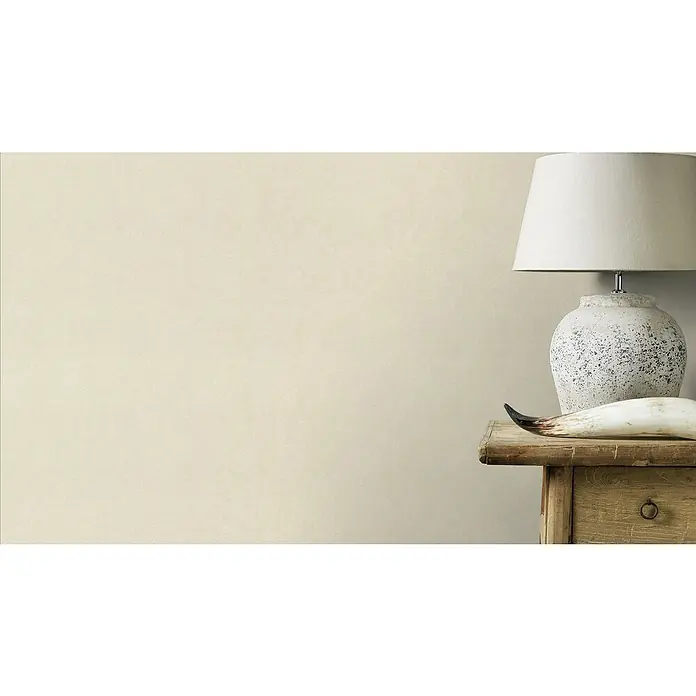 Rasch Wall Textures VI Vliestapete Uni - Beige, Uni, 10,05 x 0,53 m - Nahaufnahme eines Lampenschirms auf einer rustikalen Kommode mit dekorativem Horn, das eine warme und einladende Atmosphäre erzeugt.