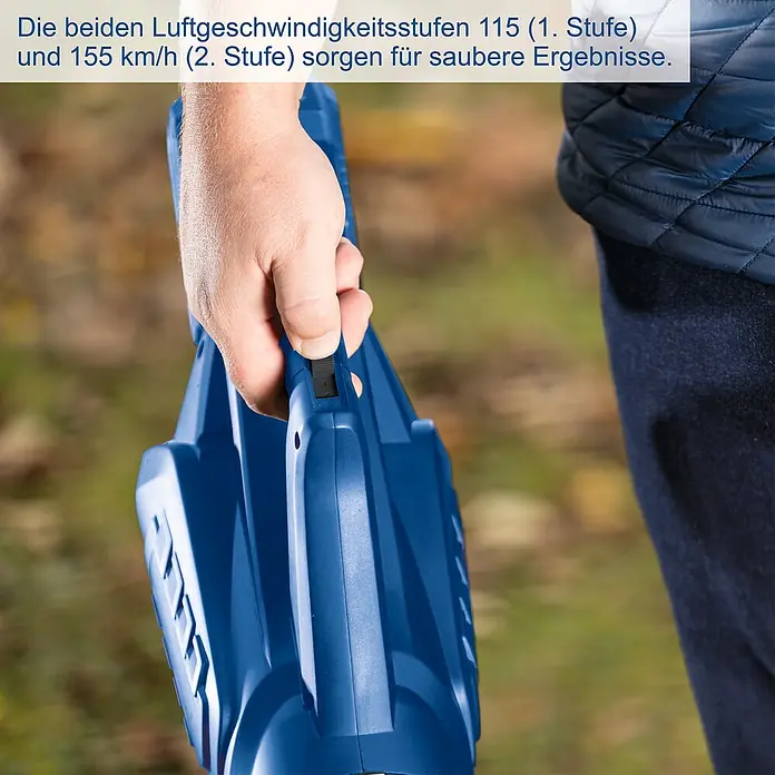 Scheppach IXES 20V Akku-Laubbläser C-BL700-X Set S - 20 V, 1 Akku, 2 Ah, Blasgeschwindigkeit: 32 m/s - 155 km/h, Blasleistung: 516 m³/h - Nahaufnahme eines blauen Laubbläsers, der von einer Hand bedient wird, mit Fokus auf den Schalter.\n