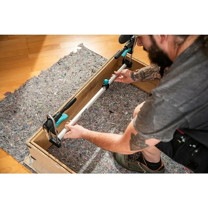 Wolfcraft Türfuttermontage-Set Pro - Passend für: Türen mit 610 - 985 mm Breite - Nahaufnahme einer Wolfcraft Spreizzwinge, die in einer Holzkonstruktion verwendet wird, auf einer Textilunterlage.