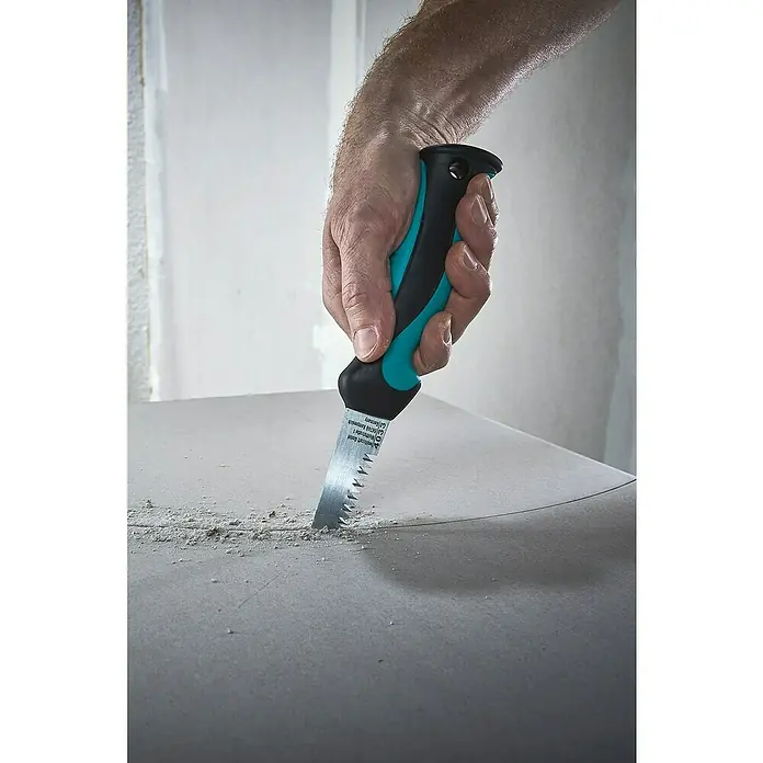 Wolfcraft Gipskartonplatten-Stichsäge - Geeignet für: Gipskartonplatten - Eine Hand benutzt eine Gipskartonsäge mit blau-schwarzem Griff, um in eine graue Gipskartonplatte zu sägen.
