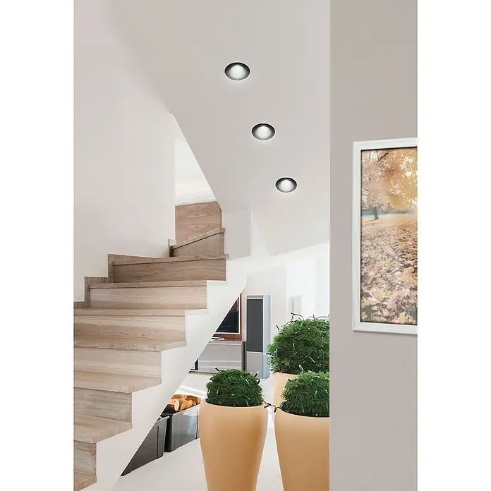 Eglo LED-Einbauleuchten-Set rund SALABATE - 18 W, Schwarz, Neutralweiß - Ein elegantes Treppenhaus mit modernen Deckenleuchten, die das minimalistische Design und die helle Farbpalette des Raumes betonen.