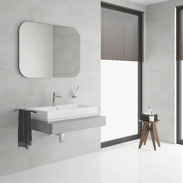 Grohe Lineare Waschtischarmatur S-Size - Push-Open-Ablaufventil, Chrom, Glänzend - Ein modernes Badezimmer mit einem Waschtisch mit rechteckigem Waschbecken, einem Spiegel und einem Hocker mit Handtüchern.