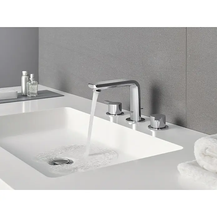 Grohe Lineare Waschtischarmatur - 3-Loch, Chrom, Glänzend - Ein moderner Waschtisch mit einer eleganten, verchromten Armatur und fließendem Wasser in einem stilvollen Badezimmer.