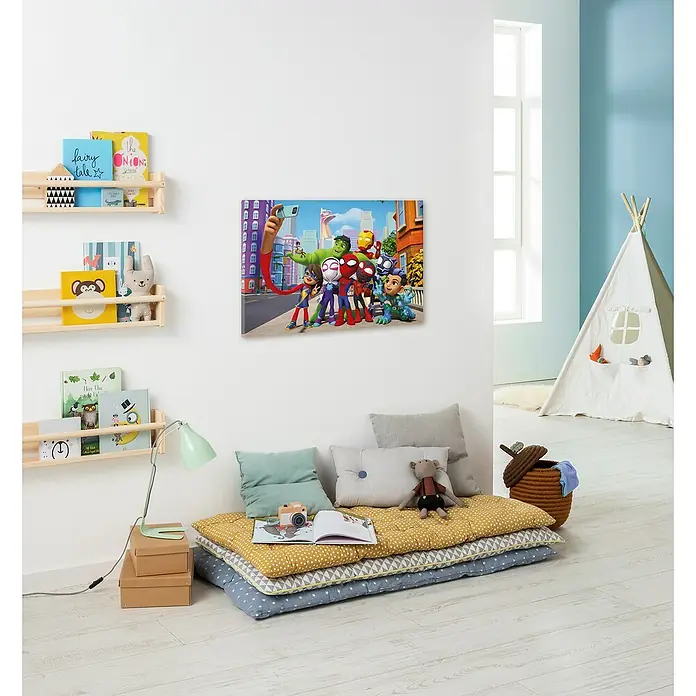Komar Leinwandbild - Spidey and his amazing Friends - Selfie, B x H: 60 x 40 cm - Ein Kinderzimmer mit einem Wandbild der Marvel Superhelden und einem gemütlichen Lesebereich mit Kissen und Decken.