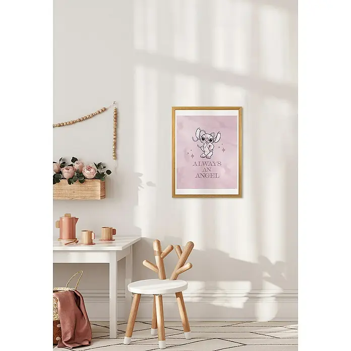 Komar Poster - Stitch always an Angel, B x H: 30 x 40 cm - Ein gerahmtes Poster mit einer Cartoonfigur und dem Schriftzug "Always an Angel" hängt an einer weißen Wand in einem Kinderzimmer.