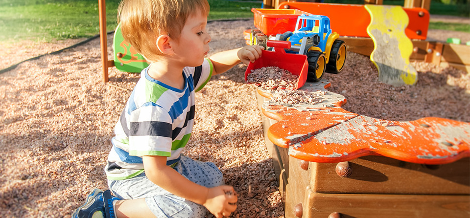 Spielendes Kind am Sandkasten im Garten