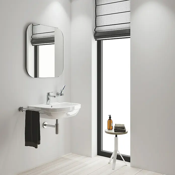 Grohe Eurosmart Cosmopolitan Waschtischarmatur M-Size mit ES-Funktion - Ohne Zugstange, Chrom, Glänzend - Ein modernes Badezimmer mit einem stilvollen Waschbecken, einem Spiegel und einem kleinen Tisch mit Handtüchern und Seife.