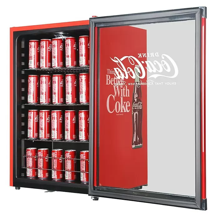 Cubes Kühlschrank High Cube - Nutzinhalt Kühlen: 115 l, L x B x H: 54,8 x 54 x 84,5 cm, Rot/Schwarz - Roter Coca-Cola Mini-Kühlschrank mit offener Glastür, gefüllt mit Cola-Dosen und Markenlogo auf der Tür.