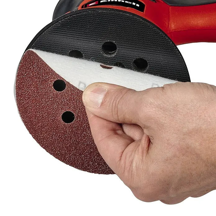 Einhell Classic Elektro-Exzenterschleifer TC-RS 425 E - 425 W, Durchmesser Schleifteller: 125 mm - Nahaufnahme eines Einhell Schleifpapiers für einen Exzenterschleifer, das von einer Hand gehalten wird.