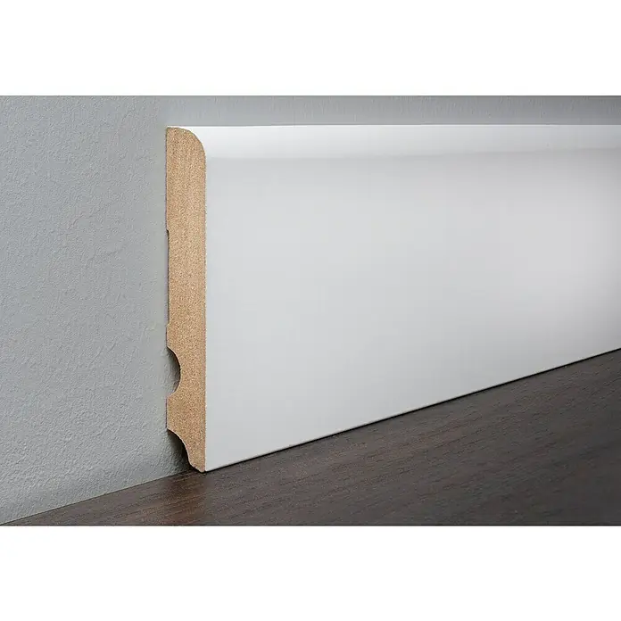 LOGOCLIC Sockelleiste Weiß - 260 cm x 15 mm x 100 mm, MDF - Nahaufnahme einer weißen Sockelleiste, die an einer grauen Wand und einem dunklen Holzboden befestigt ist.