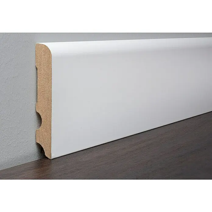 LOGOCLIC Sockelleiste Weiß - 260 cm x 16 mm x 90 mm, MDF - Nahaufnahme einer weißen Fußleiste, die an einer grauen Wand und einem dunklen Holzboden befestigt ist und einen sauberen Übergang schafft.