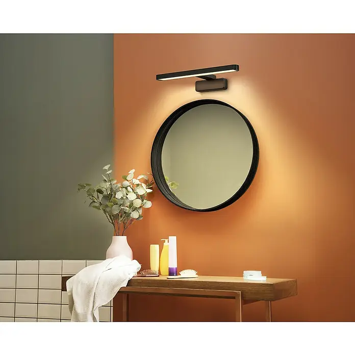 Ledvance Orbis LED-Spiegelleuchte Disc - 7 W, L x B x H: 40 x 12 x 7 cm, Schwarz, Warmweiß - Elegante Badezimmerlampe in Schwarz über einem runden Spiegel. Warmes Licht akzentuiert die Wandfarbe und die Badaccessoires.