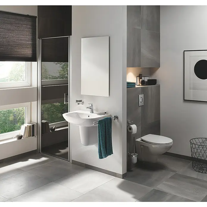 Grohe BauFlow Waschtischarmatur S-Size - Chrom, Glänzend - Helles Badezimmer mit moderner Toilette, Waschbecken und Spiegel. Das Design ist minimalistisch und funktional, ideal für kleine Räume.