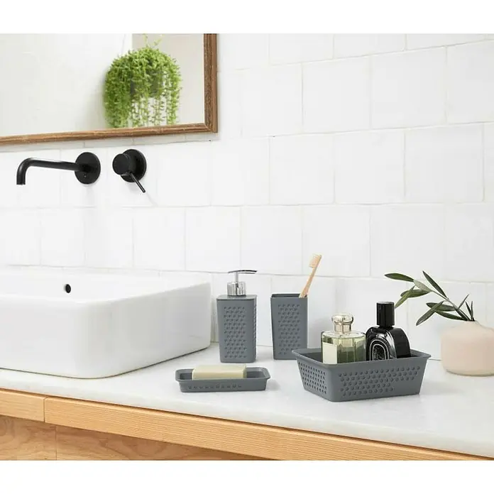 Tatay Bohol Dispensador de jabón - L x An x Al: 7 x 65 x 16 cm, Plástico, Antracita - Accesorios de baño grises sobre una superficie brillante, incluyendo dispensador de jabón, porta cepillos y cesta de almacenamiento.