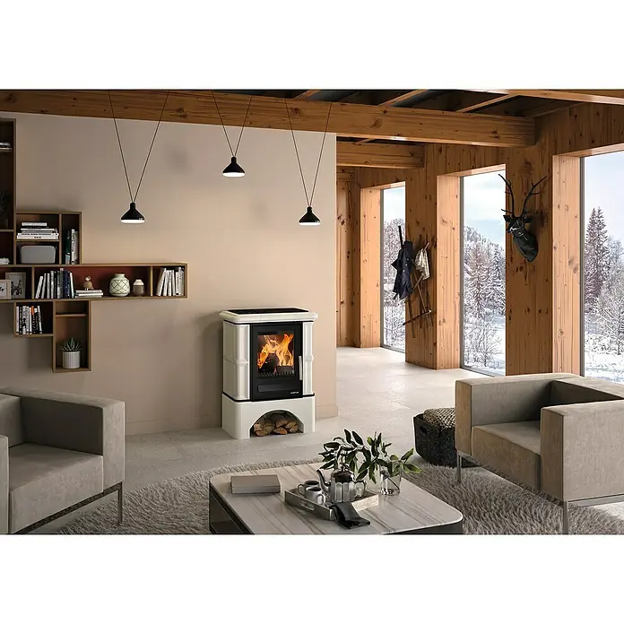 Justus Kaminofen Bavaria - 7 kW, Raumheizvermögen: 144 m³, Material Verkleidung: Keramik, Ahorn weiß - Wohnzimmer mit einem Justus Kaminofen, Regalen, Deckenleuchten und Sesseln.