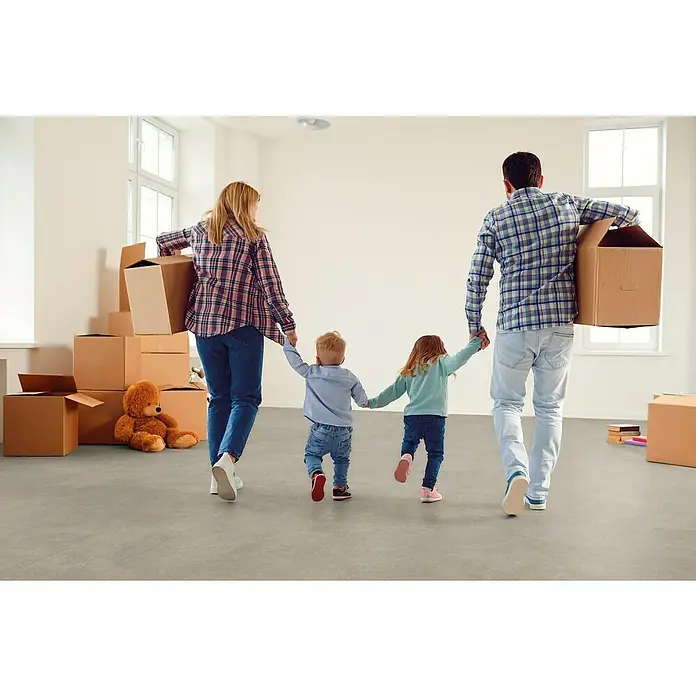 Decolife Designboden Naturestyle Pure - Concrete Grey, Fliese, 905 x 295 x 9 mm - Eine Familie zieht mit ihren Habseligkeiten und Kartons in ein neues Haus ein. Sie freuen sich auf einen neuen Lebensabschnitt.