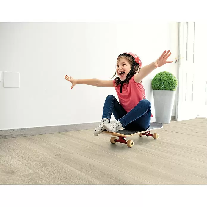 Decolife Designboden Naturestyle Pure - Oak Ash, Landhausdiele, 1.220 x 185 x 9 mm - Helles Holzparkett in einem hellen Raum, in dem ein Kind spielt.