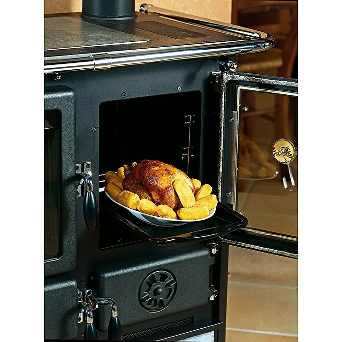 La Nordica Küchenherd Rosetta - 8,8 kW, Raumheizvermögen: 206 m³, Mit Holzfach, Schwarz/Serpentino - Ein Holzofen mit einem gebratenen Huhn und Kartoffeln im Ofen. Ideal zum Kochen und Backen mit rustikalem Charme.