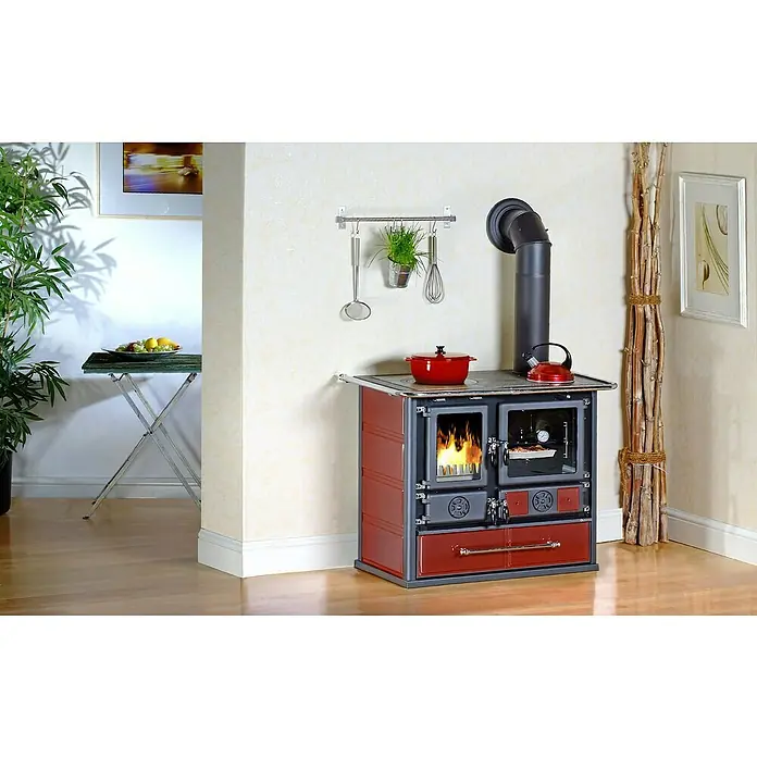 La Nordica Küchenherd Rosa - 6,5 kW, Raumheizvermögen: 185 m³, Mit Holzfach, Schwarz/Bordeaux - Küchenambiente mit einem traditionellen Holzofen, rotem Topf und Wasserkocher. Ein Blickfang für Liebhaber des Landhausstils.
