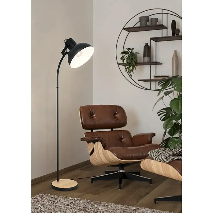 Eglo Lubenham Stehleuchte - 28 W, Höhe: 160 cm, Schwarz, E27 - Schwarze Stehlampe mit verstellbarem Schirm und einem hellen Holzfuß neben einem braunen Ledersessel.