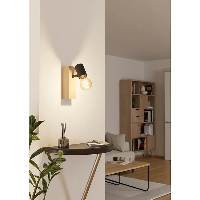 Eglo Townshend 3 Wandstrahler - 10 W, Braun/Schwarz, E27, 1 Stk. - Eine moderne Wandleuchte mit einem hölzernen Sockel und einem schwarzen Lampenkopf beleuchtet stilvoll einen Raum mit minimalistischem Design.