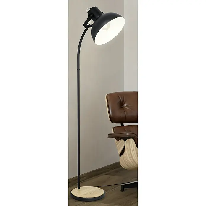 Eglo Lubenham Stehleuchte - 28 W, Höhe: 160 cm, Schwarz, E27 - Nahaufnahme einer schwarzen Stehlampe mit rundem Lampenschirm, die Licht spendet, neben einem modernen Ledersessel platziert.