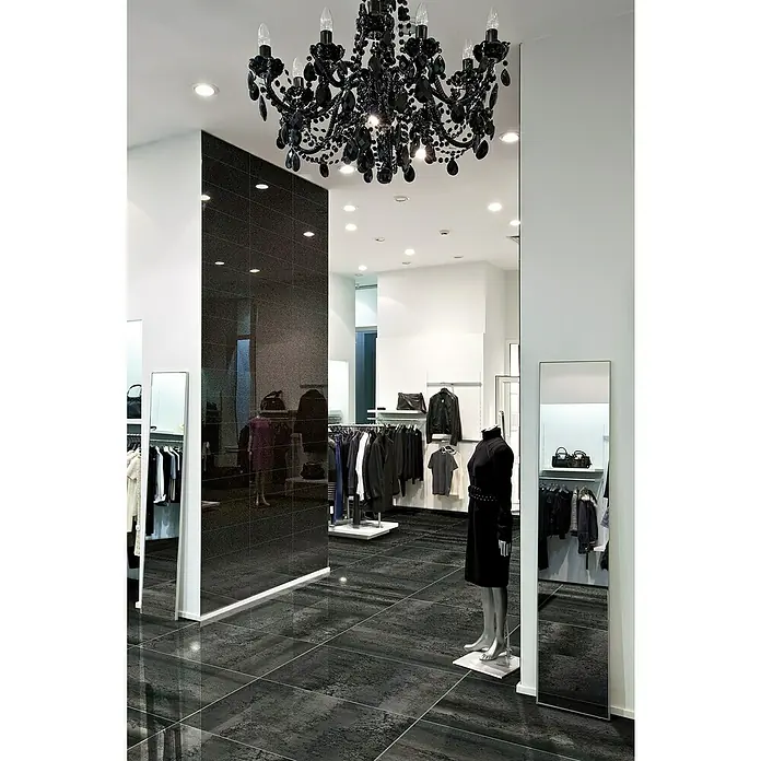 Azteca Feinsteinzeugfliese Cosmos Lux - L x B: 60 x 60 cm, Negro - Elegante Boutique mit einem auffälligen schwarzen Kronleuchter und dunklem Fliesenboden, die das luxuriöse Ambiente des Geschäfts hervorheben.